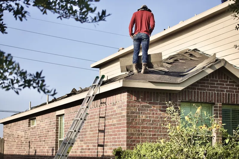Professional roofer working on a residential roof in Owl
